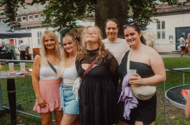 Freundesgruppe lacht gemeinsam auf dem Festivalgelände